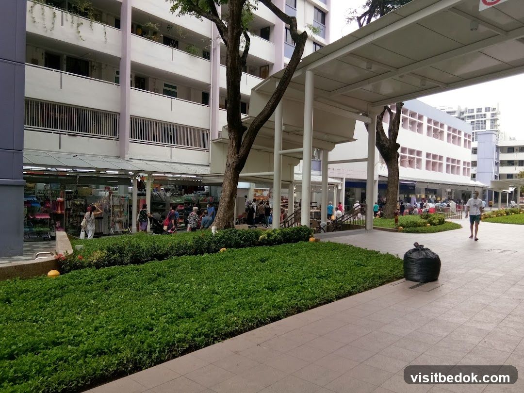 Outdoor walkway with shops and greenery