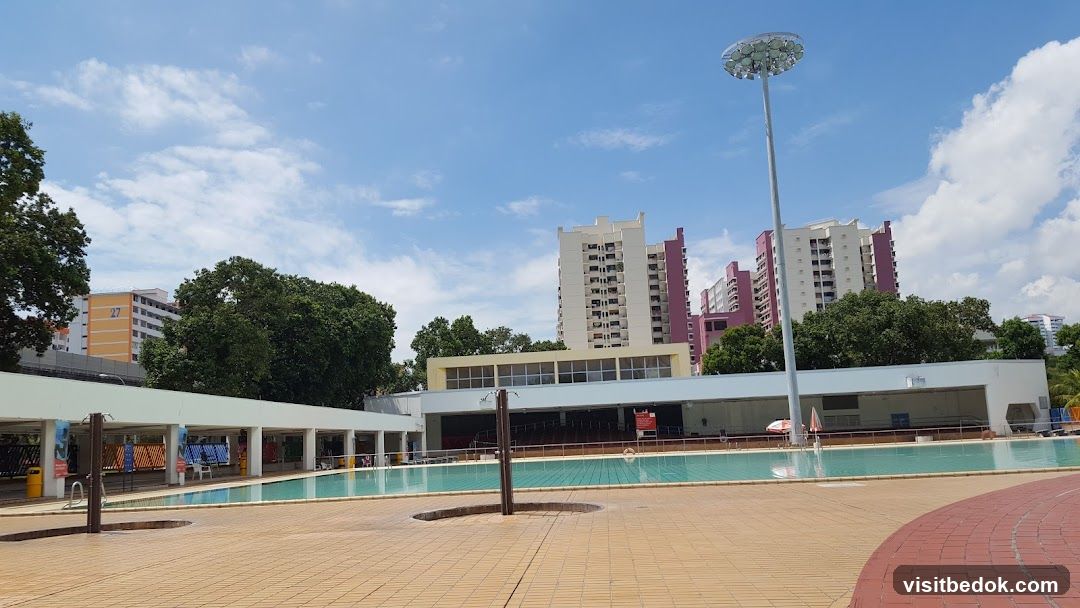 Outdoor swimming pool with apartment buildings in the background