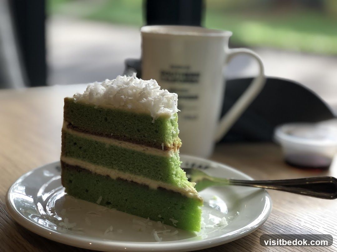 Slice of green cake with coconut flakes