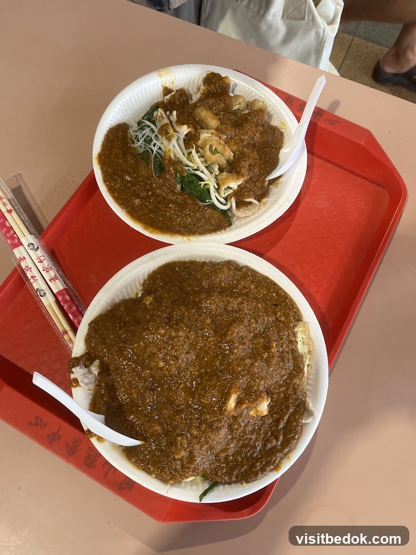 Two plates of food with peanut sauce