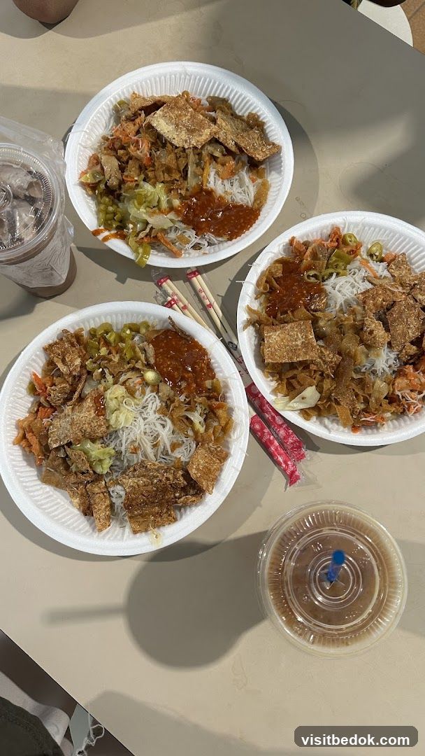 Three bowls of noodles with toppings and drinks