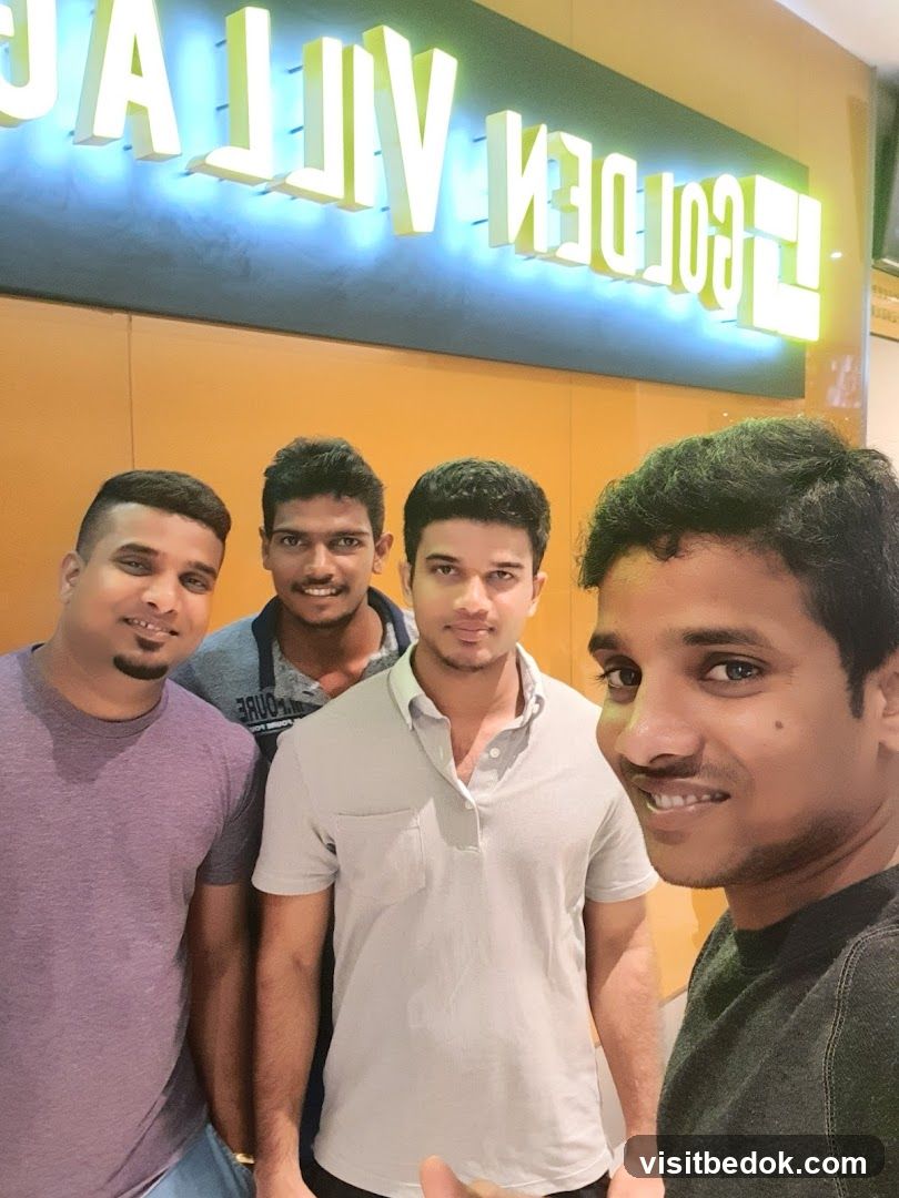 Four men posing for a selfie in front of a sign