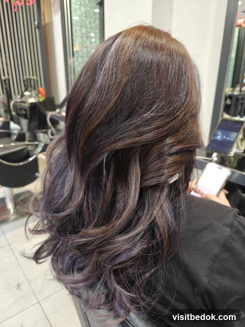Woman with styled brown hair with purple highlights