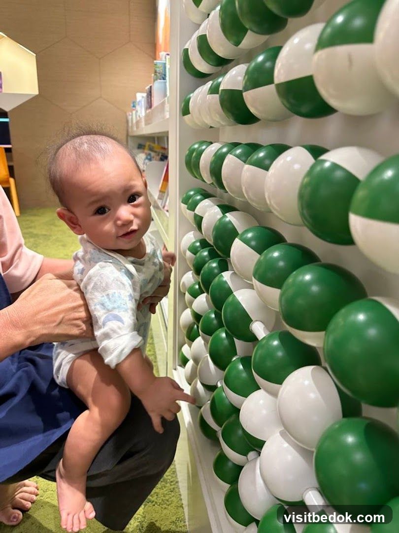 Baby interacting with a wall of spheres