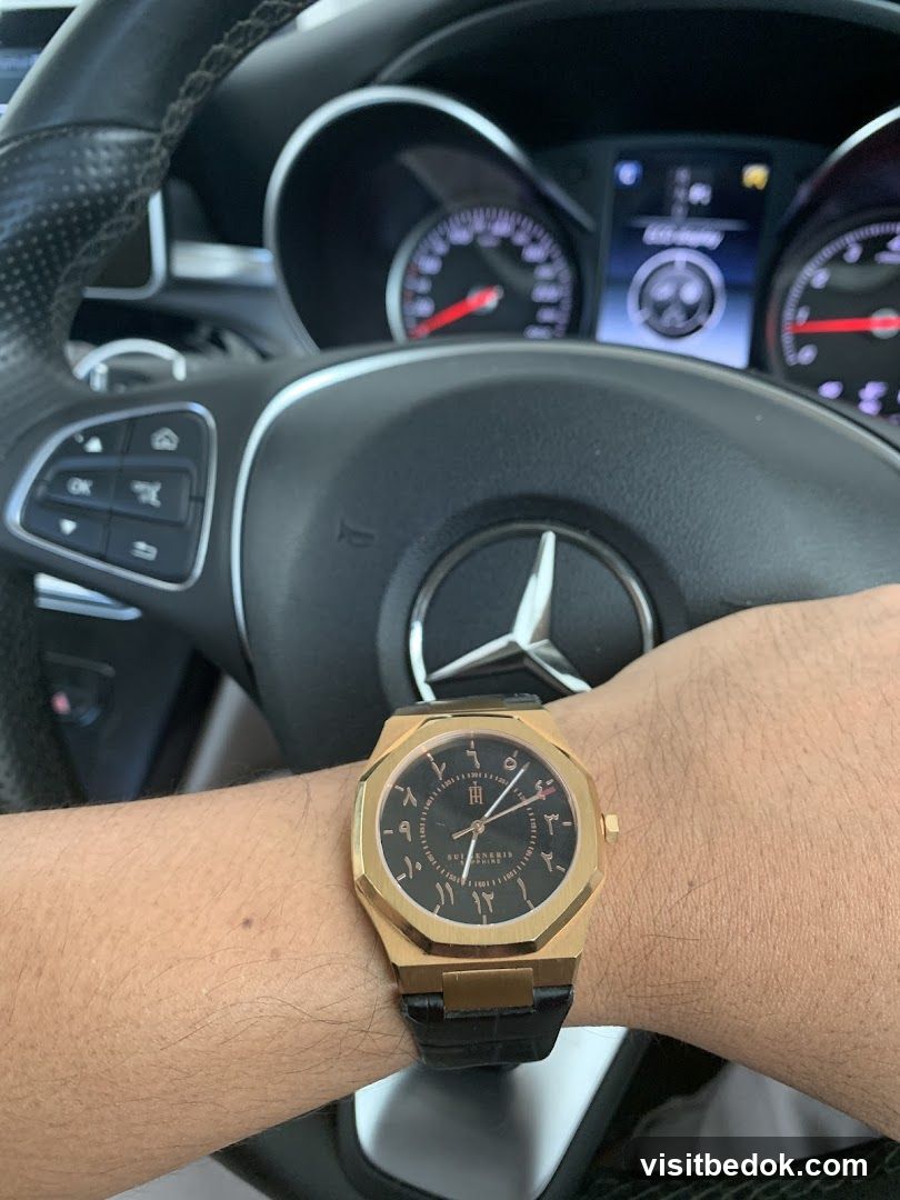 Man wearing a gold watch with Arabic numerals