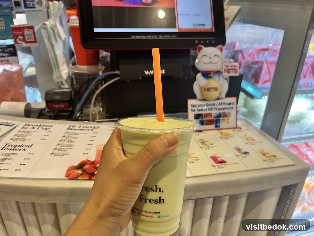 Person holding a smoothie in front of a counter