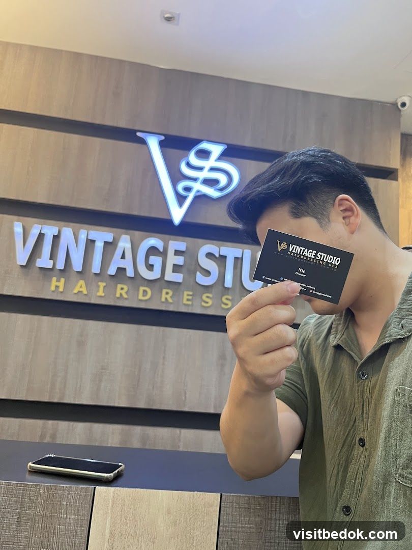 Man holding a business card in front of a salon sign