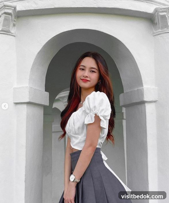 Young woman posing in white archway