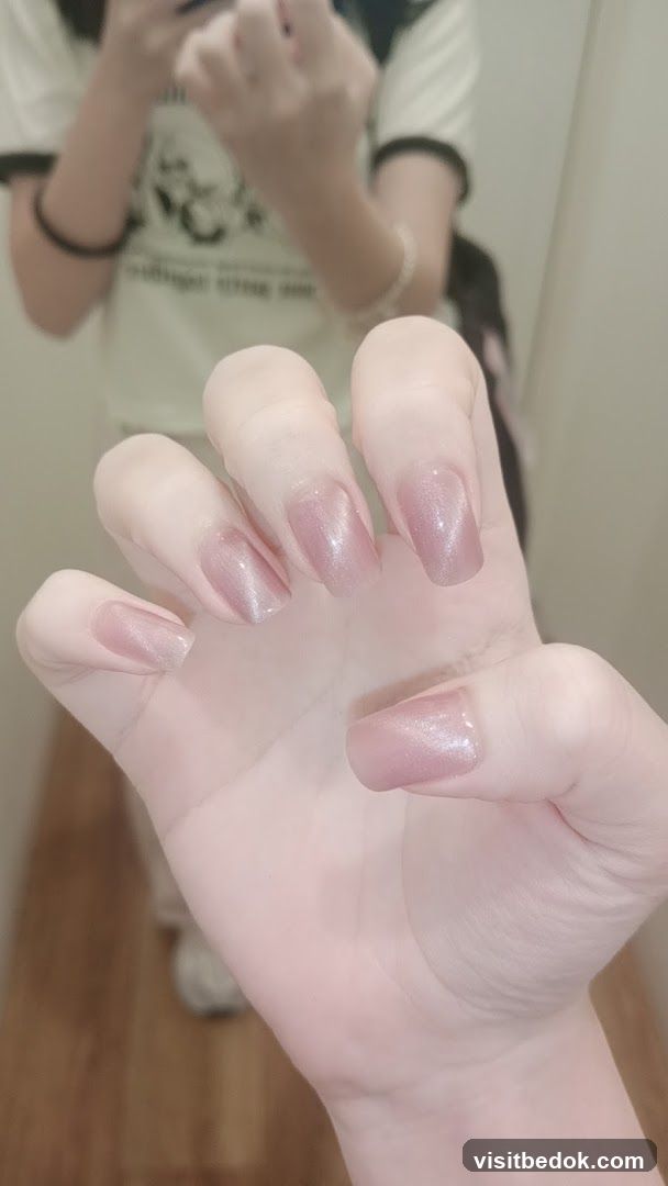 Woman's Hand with Pink Shimmer Nails