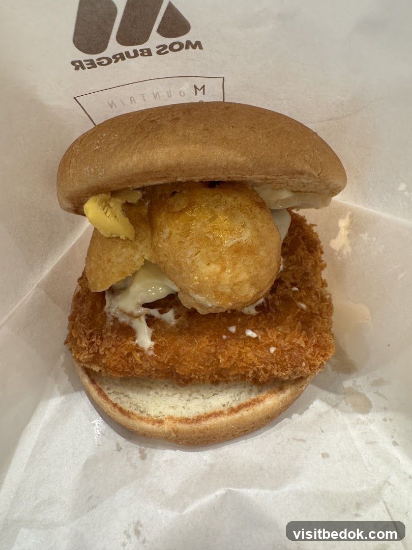Burger with fried fish and potato balls