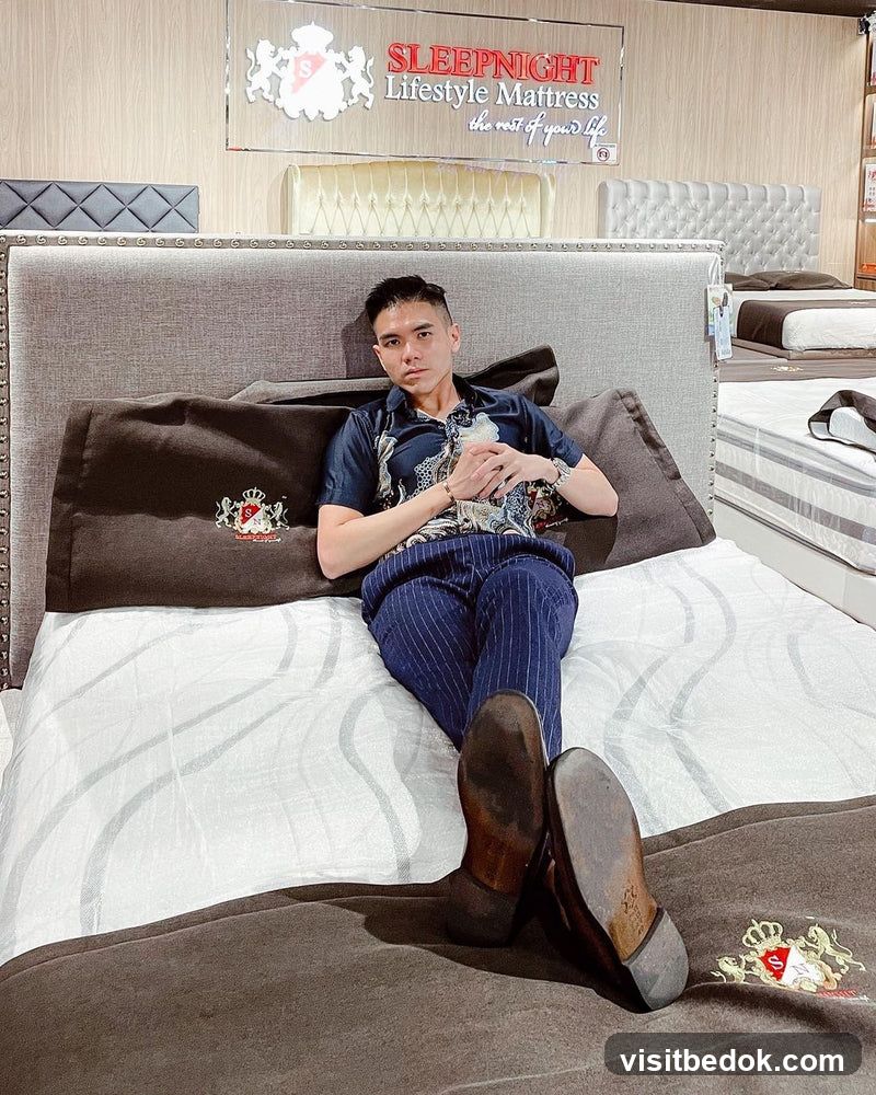 Man lounging on a mattress in a store
