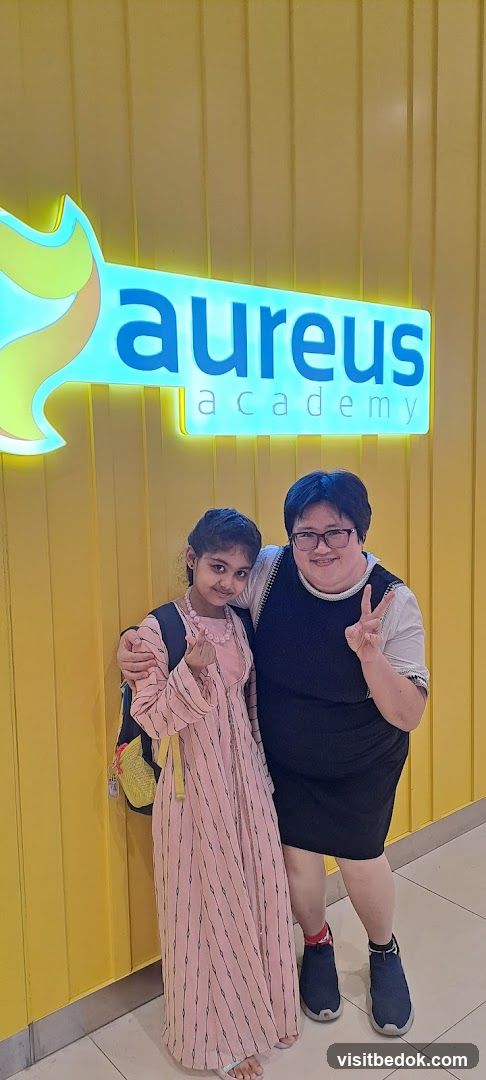 Two people posing in front of a sign