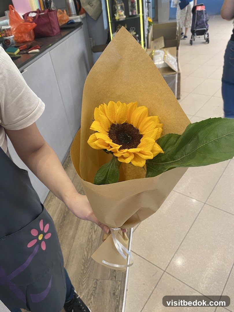 Person holding a sunflower bouquet