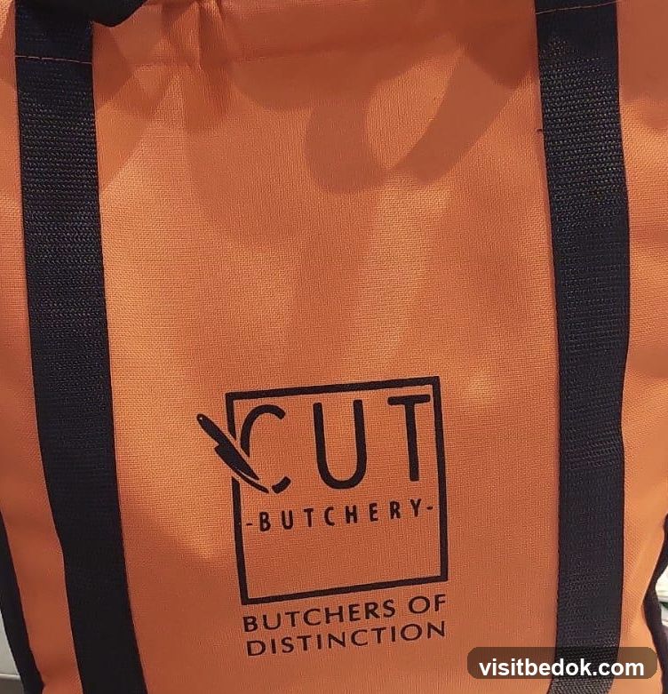 Orange tote bag with butcher shop logo