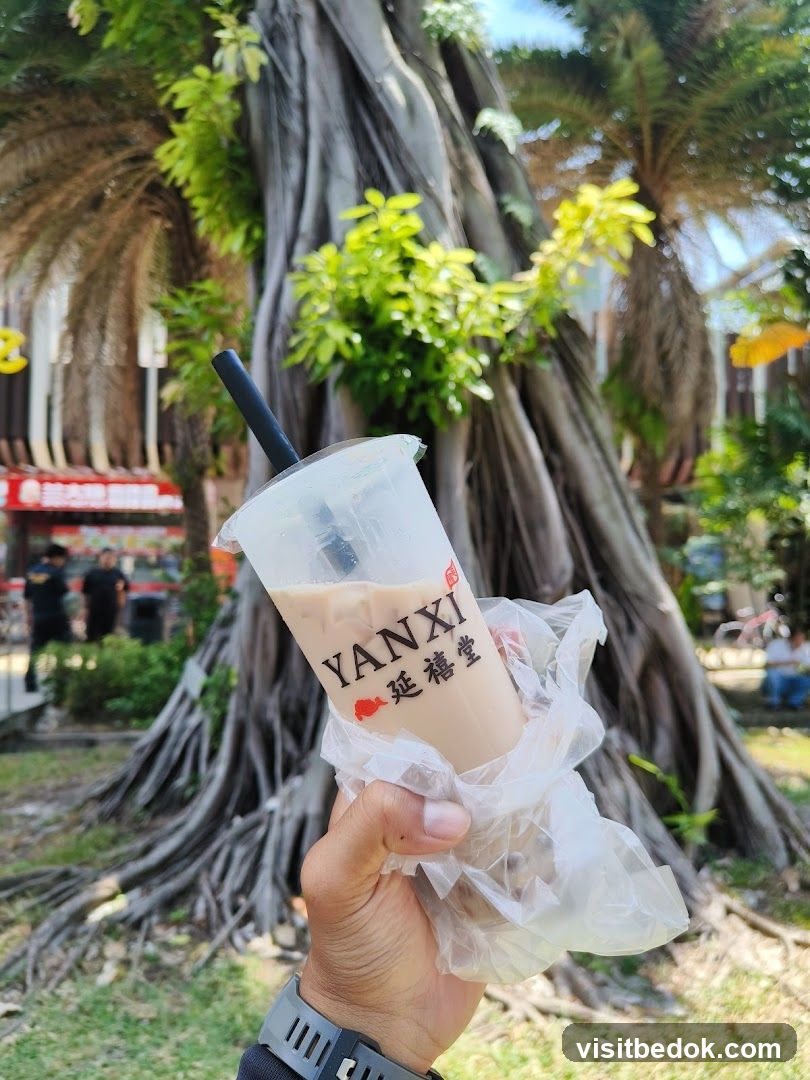Hand holding a YANXI drink