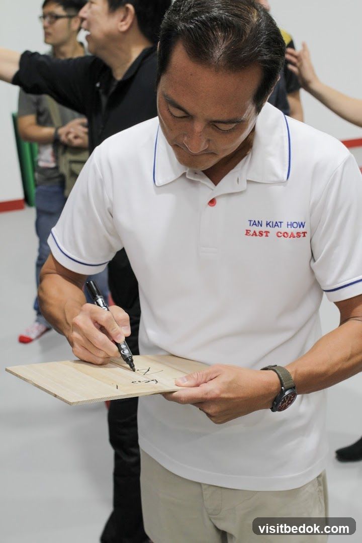 Man signing a wooden board