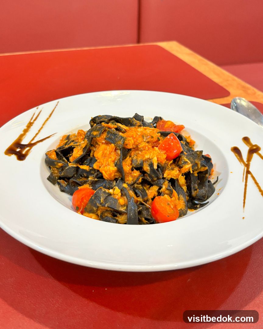 Black pasta with tomato sauce and cherry tomatoes
