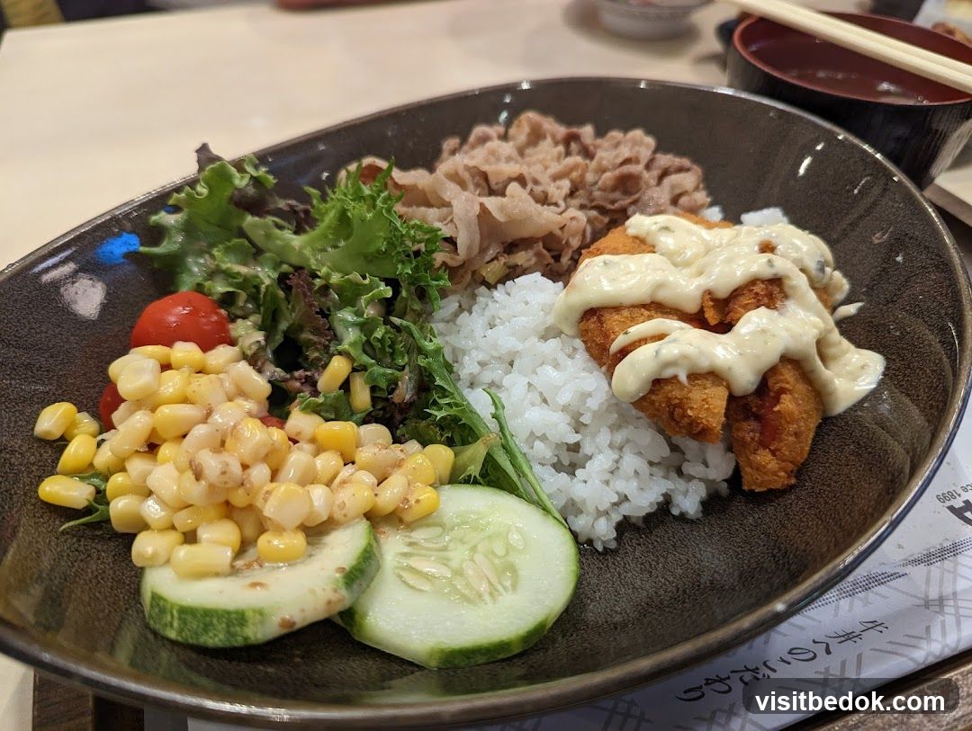 Rice bowl with fried fish and salad