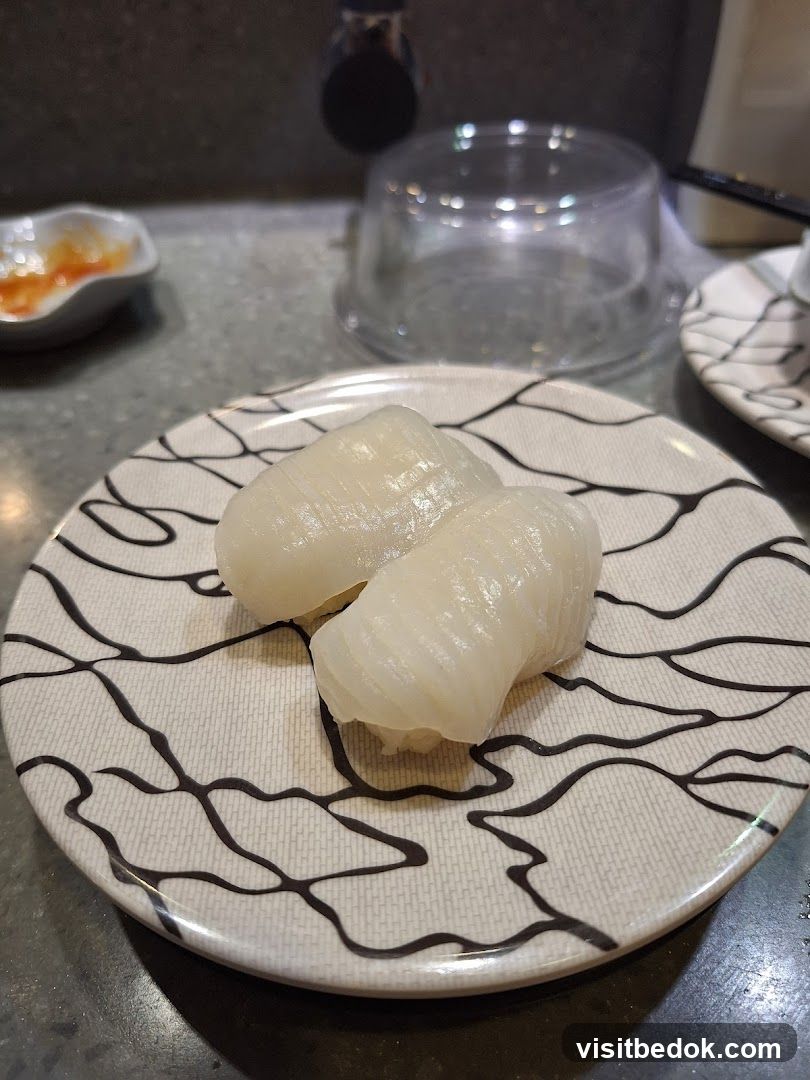 Two pieces of squid sushi on a plate