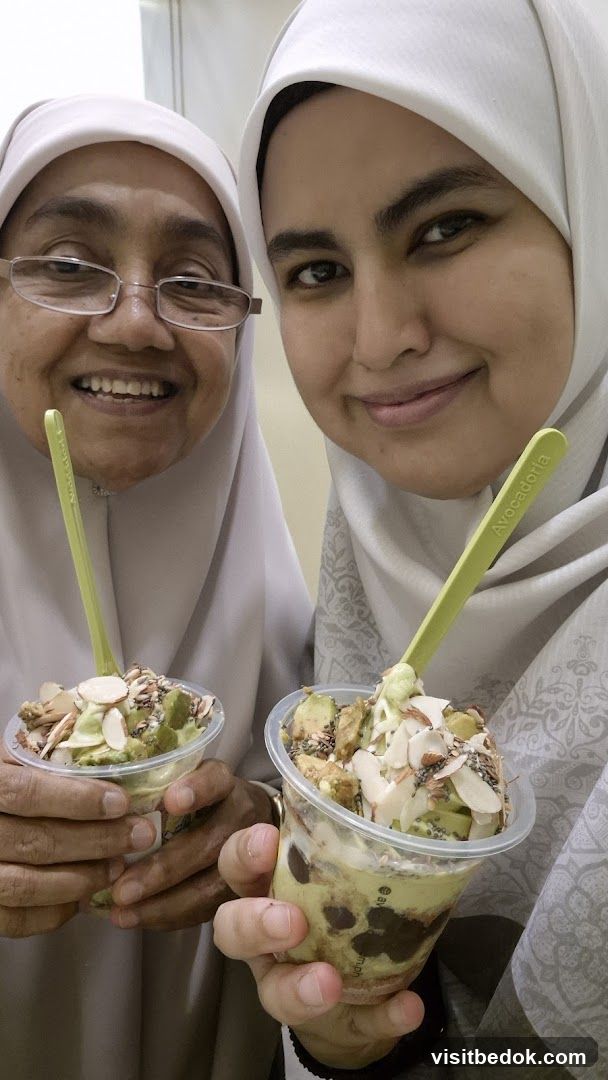 Two women holding avocado desserts