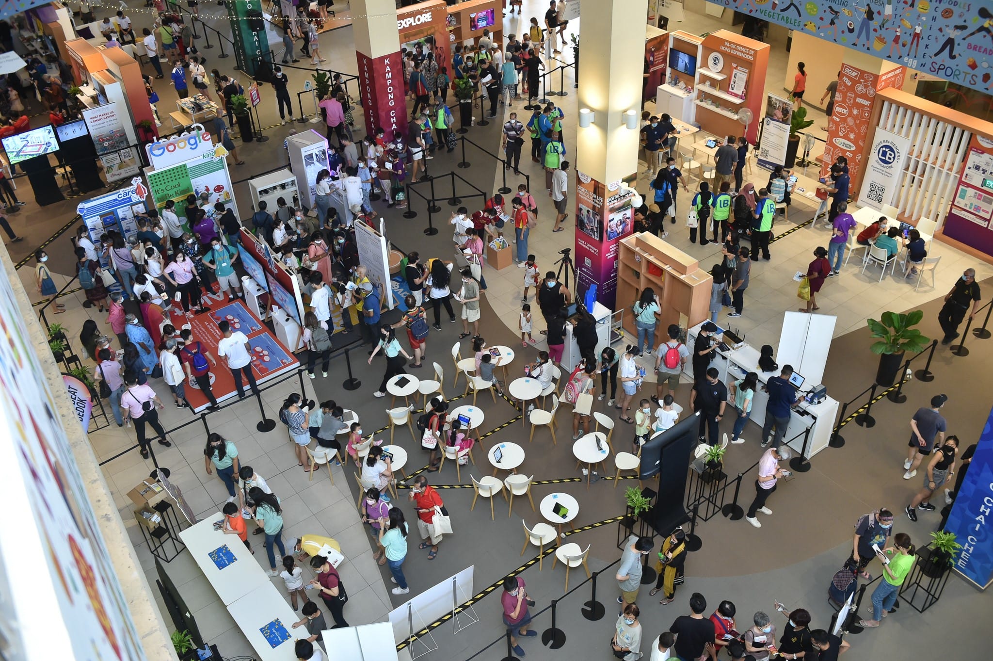 Town Square atrium at Heartbeat@Bedok during a digital skills fair, with booths and queues on the ground floor